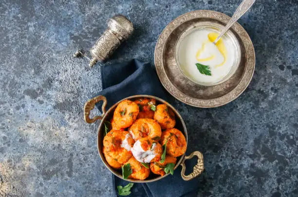 Photo of Traditional Turkish food - fellah koftes, polpettes from bulgur and semolina in tomato sauce with parsley and ayran. Middle eastern food concept.