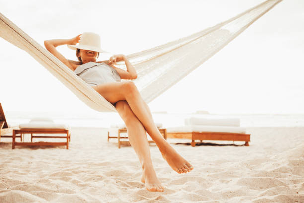 istock Woman relaxing in hammock on beach 959864650