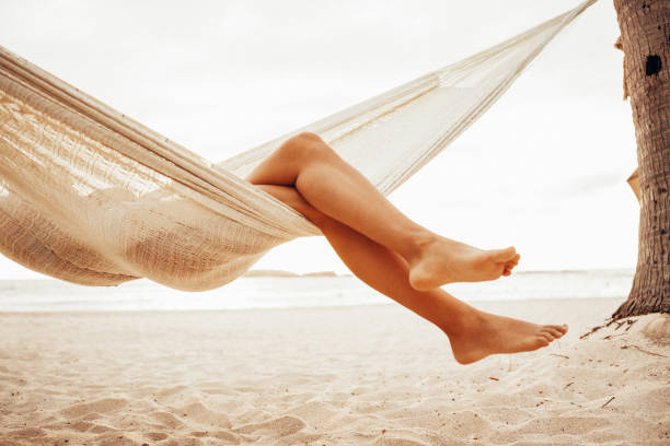 istock Woman relaxing in hammock on beach 959866402
