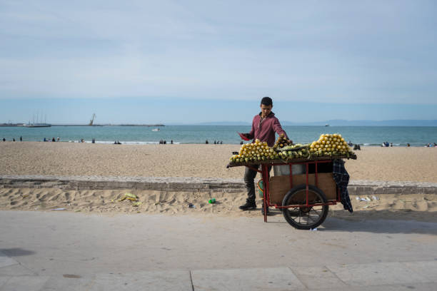 Barranca, Peru - January 22, 2015: Male Peruvian beach trader with his mobile ice cream stall ibn tricycle on Barranca Beach on the Pacific Coast to the north of Lima