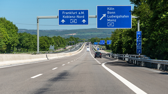 German highway with visible cars, signs and exits. Motorway without speed limit.
