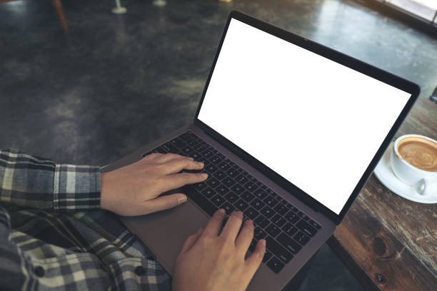 istock Top view mockup image of businessman using and typing on laptop with blank white desktop screen while sitting on a chair 959873404