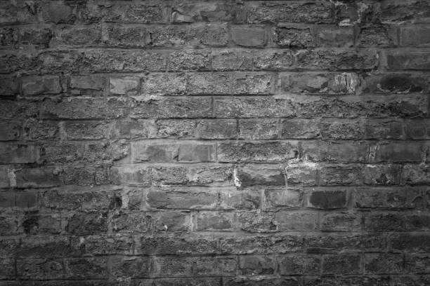 istock Old brick wall as background, texture or pattern. Dark wall. Poster or cover. Black and white brick wall. 959874730
