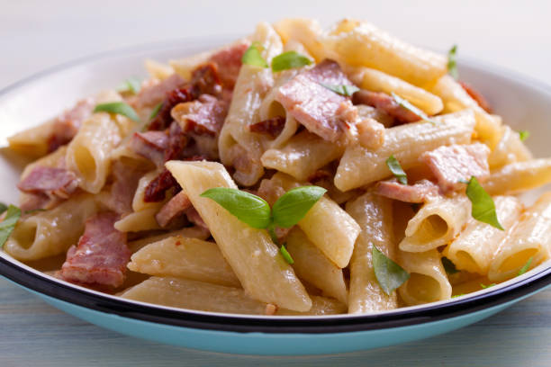 istock Penne pasta with bacon and sundried tomatoes 959879500