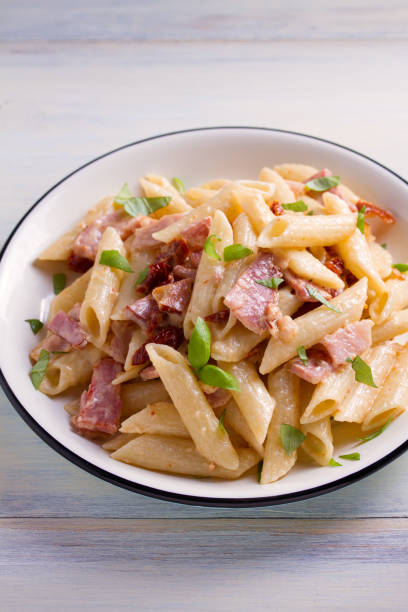 istock Penne pasta with bacon and sundried tomatoes 959879650