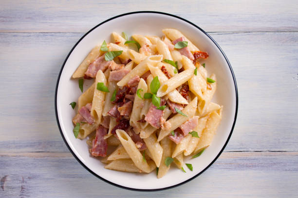 istock Penne pasta with bacon and sundried tomatoes 959879884