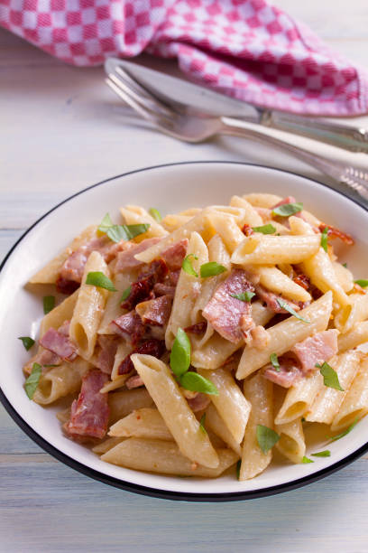 istock Penne pasta with bacon and sundried tomatoes 959880900