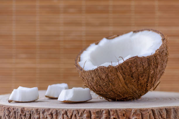 istock a half of coconut and pieces on brown background 959889480