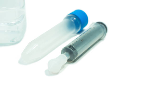Green Earth Research - Test Tube & Syringe displays a gloved hand holding a test tube or vile of green liquid as a syringe is dripping into the tube