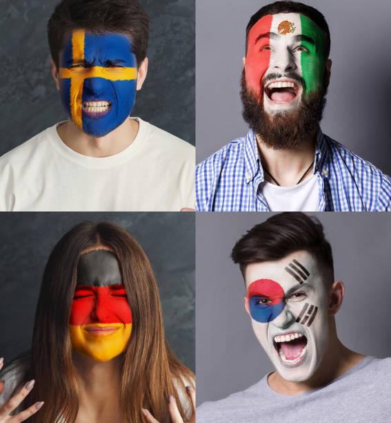 istock Emotional soccer fans with painted flags on faces 959897796