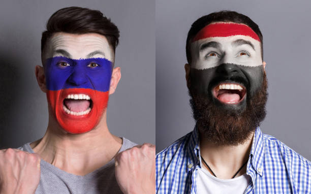 istock Emotional soccer fans with painted flags on faces 959897860