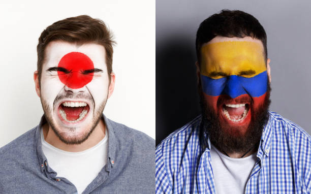 istock Emotional soccer fans with painted flags on faces 959897918