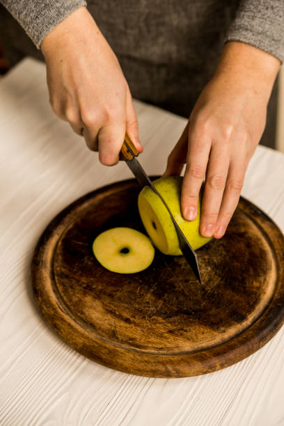 istock Woman cuts green apple on board close 959900634