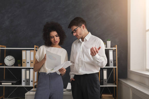 istock Couple of young colleagues work at modern office 959901114