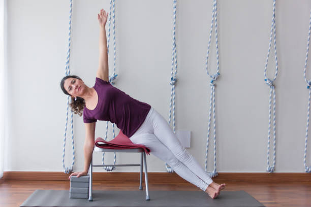 istock Iyengar yoga teacher performs asana with props on mat in studio 959902950