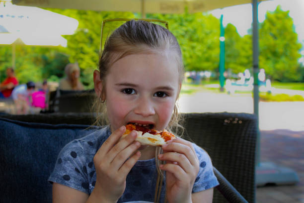 istock Little girl eating pizza 959905758
