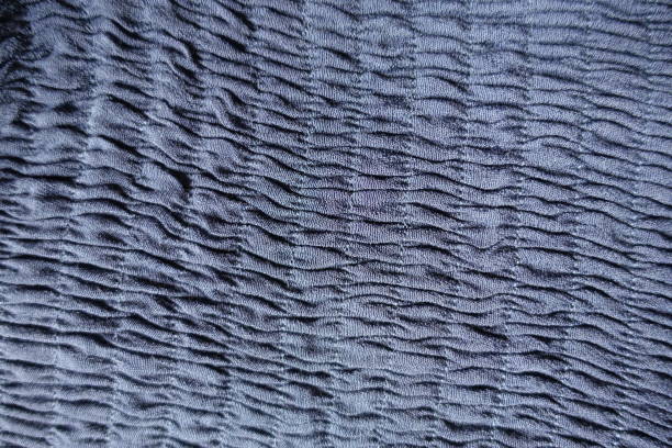 Vertical rows of gathers (shirring) on blue fabric