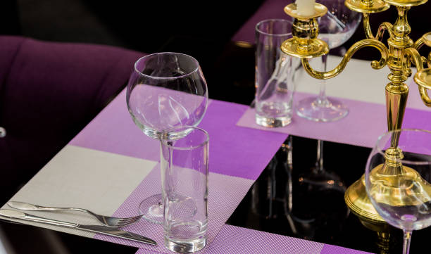 istock Glasses and a candlestick on a glass table in a restaurant. Romantic setting 959911966