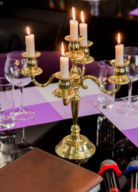 istock Glasses and a candlestick on a glass table in a restaurant. Romantic setting. Microphones for karaoke 959914432