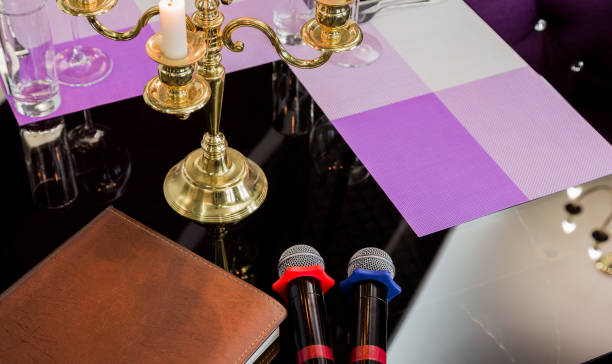 istock Glasses and a candlestick on a glass table in a restaurant. Romantic setting. Microphones for karaoke 959914720