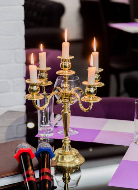 istock Glasses and a candlestick on a glass table in a restaurant. Romantic setting. Microphones for karaoke 959914980