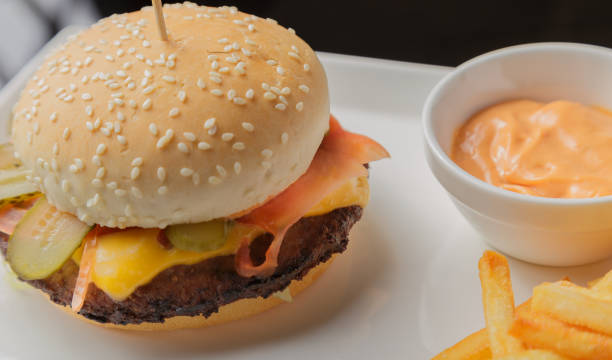 istock Burger on a plate with fried potatoes and sauce 959918926
