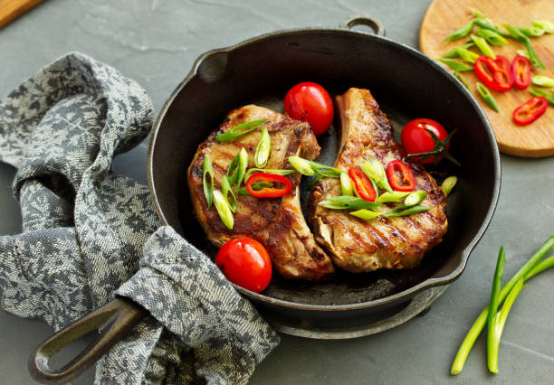 istock Pork cutlet on a bone with baked vegetables. 959919698