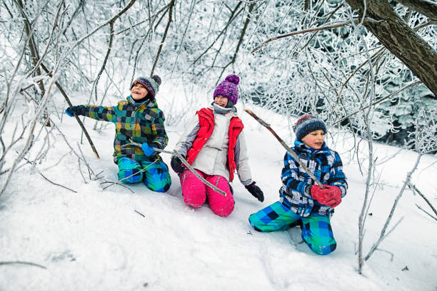 istock Happy kids playing in frozen winter forest 959923284