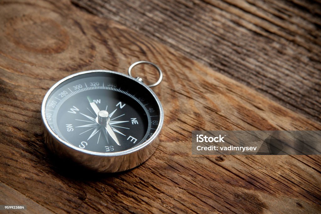 Compass on a wooden background Compass on a old wooden background. Travel concept. Navigational Compass Stock Photo