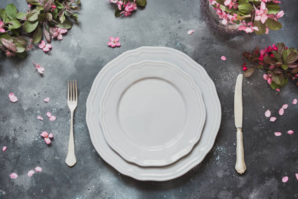 istock Spring table place setting with romance pink flowers, silverware on vintage background. View from above. 959928032