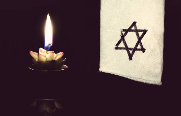 The star of David and candle stands The star of David and candle stands on the table on a black background in memory of the victims of the Holocaust and genocide. concentration camp photos stock pictures, royalty-free photos & images