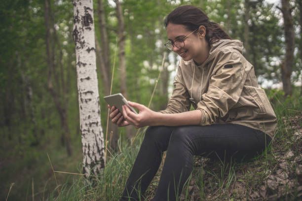 istock Young woman uses tablet outdoors 959933034