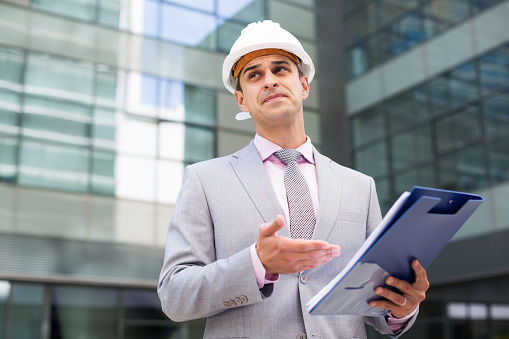 Businessman holding folder with documents and attentively reading