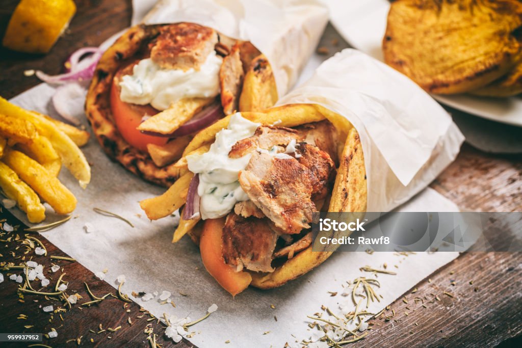 Greek gyros wraped in a pita bread on a wooden background Kebab Stock Photo