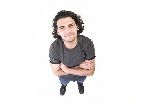High angle view of happy young man looking at camera on white background. Horizontal composition. Studio shot.