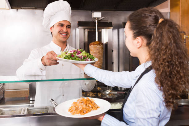 istock Happy waitress receiving order from chef 959939122
