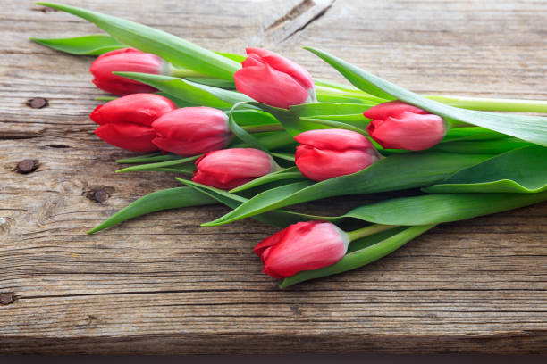 istock Red tulips bouquet on a wooden background 959941874
