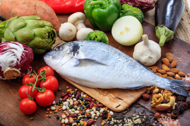 istock Raw fish and vegetables on wooden background 959952704