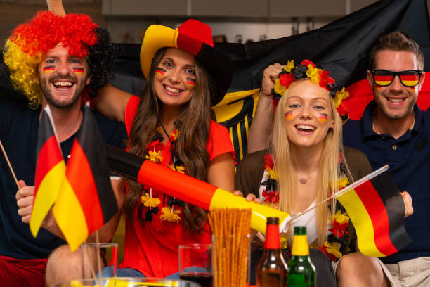 istock four happy german soccer fans at home 959960492