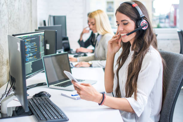 istock Smiling young woman with headset using phone in office 959964248