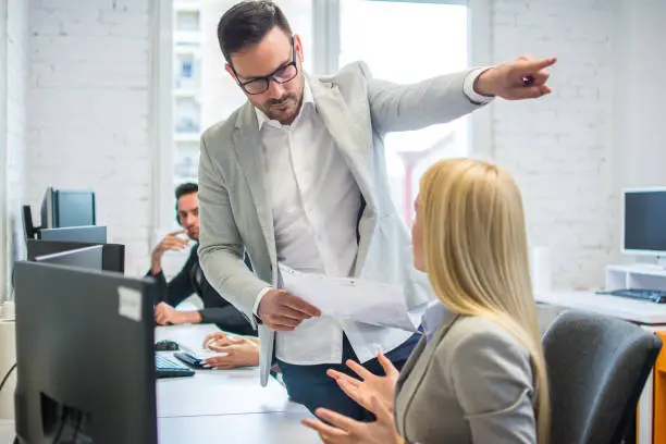 Photo of Getting fired. Angry boss pointing female employee on exit way.