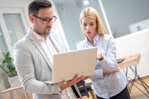 istock Business people looking together on laptop in office. 959964690