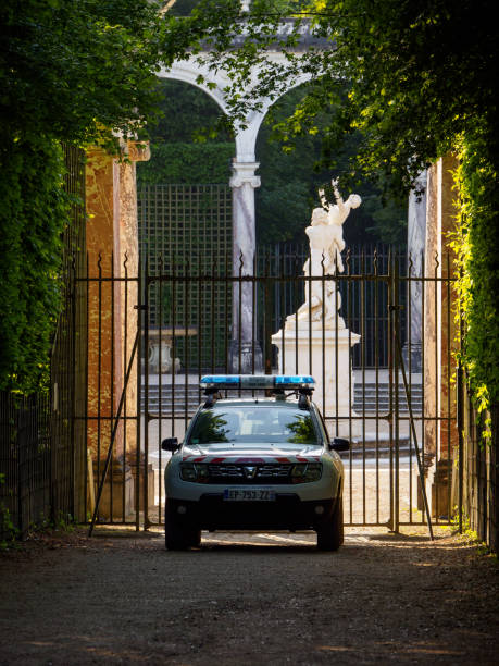 coche de policía estacionado frente a columnata arboleda, jardines de versalles, francia - statue architecture sculpture formal garden fotografías e imágenes de stock