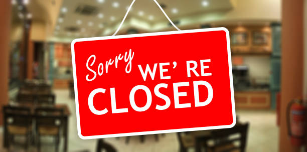 istock Sorry we are closed sign hanging on a glass storefront 959970044