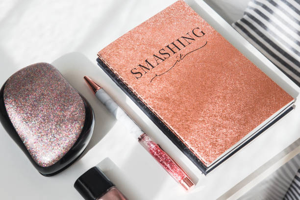 istock Rose gold glitter notebook and pen on white 959970896