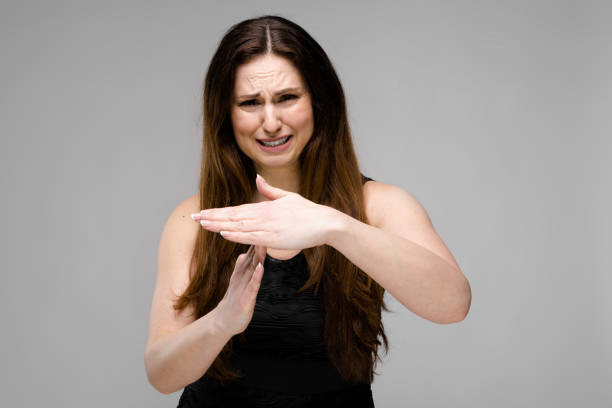 istock Emotional sad plus size model standing in studio showing stop gesture show time-out sign 959974400