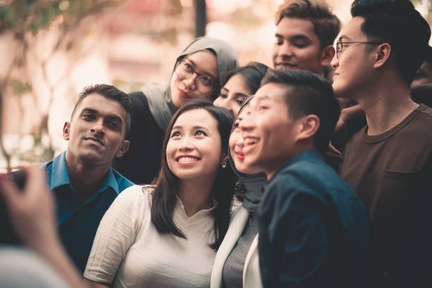 istock a group of young adults taking selfie 959978612