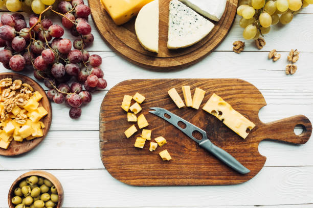 istock flat lay with various types of cheese, grapes and knife on wooden surface 959982052