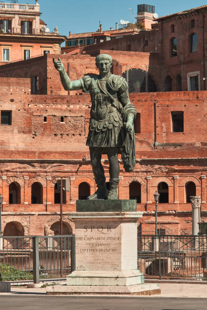 roma, statua in bronzo dell'imperatore cesare nervae traiano, foro di cesare nervae traiano sullo sfondo - forum of nerva foto e immagini stock