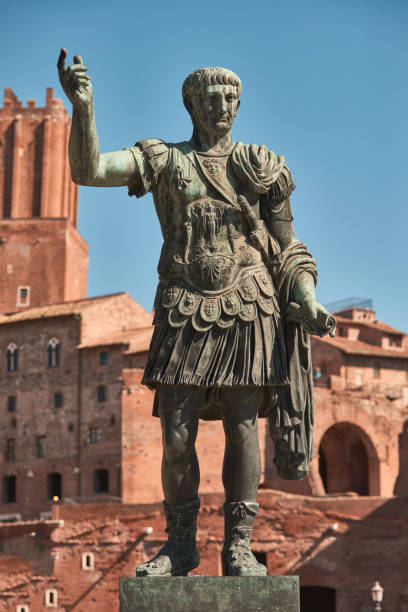 roma, statua in bronzo dell'imperatore cesare nervae traiano, foro di cesare nervae traiano sullo sfondo - forum of nerva foto e immagini stock